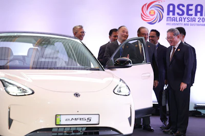 Chinese Premier Li Qiang, right, reacts as he, along with Malaysian Prime Minister Anwar Ibrahim, center, inspects a car produced by Malaysia's national automaker, Proton, in which China's Zhejiang Geely Holding Group holds a 49.9% stake, ahead of the signing ceremony for the ASEAN&ndash;China Free Trade Area 3.0 Upgrade and the ASEAN&ndash;China summit, held as part of the ASEAN summit in Kuala Lumpur, Malaysia Tuesday, Oct. 28, 2025.