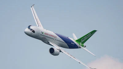 Attendees pass by a model of the Chinese-made C919 passenger jet at the Sinochem booth during the China International Supply Chain Expo in Beijing, Nov. 27, 2024.