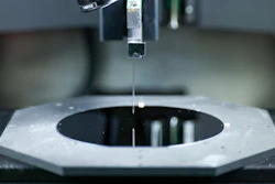 A closeup look at the tiny needle used in the Hummink printing technology. The needle is essentially attached to a tuning fork, which moves the needle rapidly above the printing surface. Natural competing surface energies pull tiny amounts of ink out to print designs with submicrometer precision.