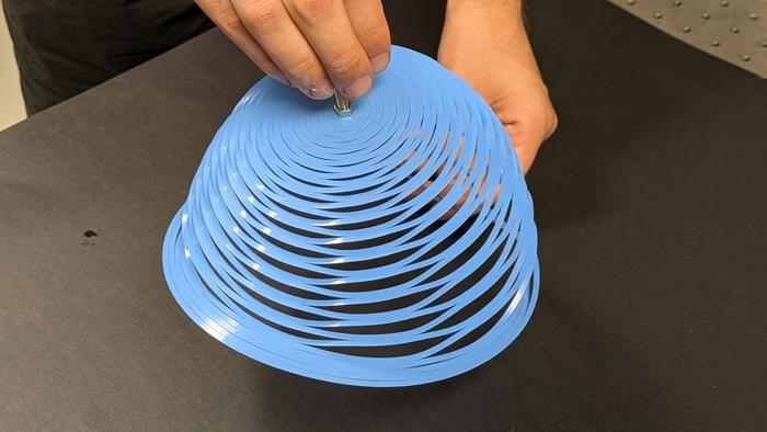 Laser cutting of a closed-loop kirigami pattern allows a plastic sheet to adopt the shape of an inverted bell.