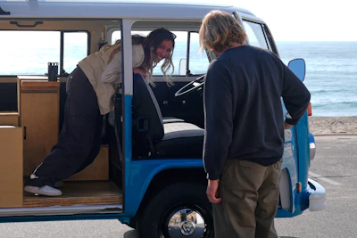Megan Krystle Weinraub, left, and Preston Martin, who is the former owner, look over her Volkswagen bus as they see it for the first time Monday, Oct. 27, 2025, in Malibu, Calif., after it was restored by VW.