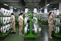 Workers check on the products in the world's largest production base for recycled polyester filament yarn, Siyang, China, Oct. 24, 2025.