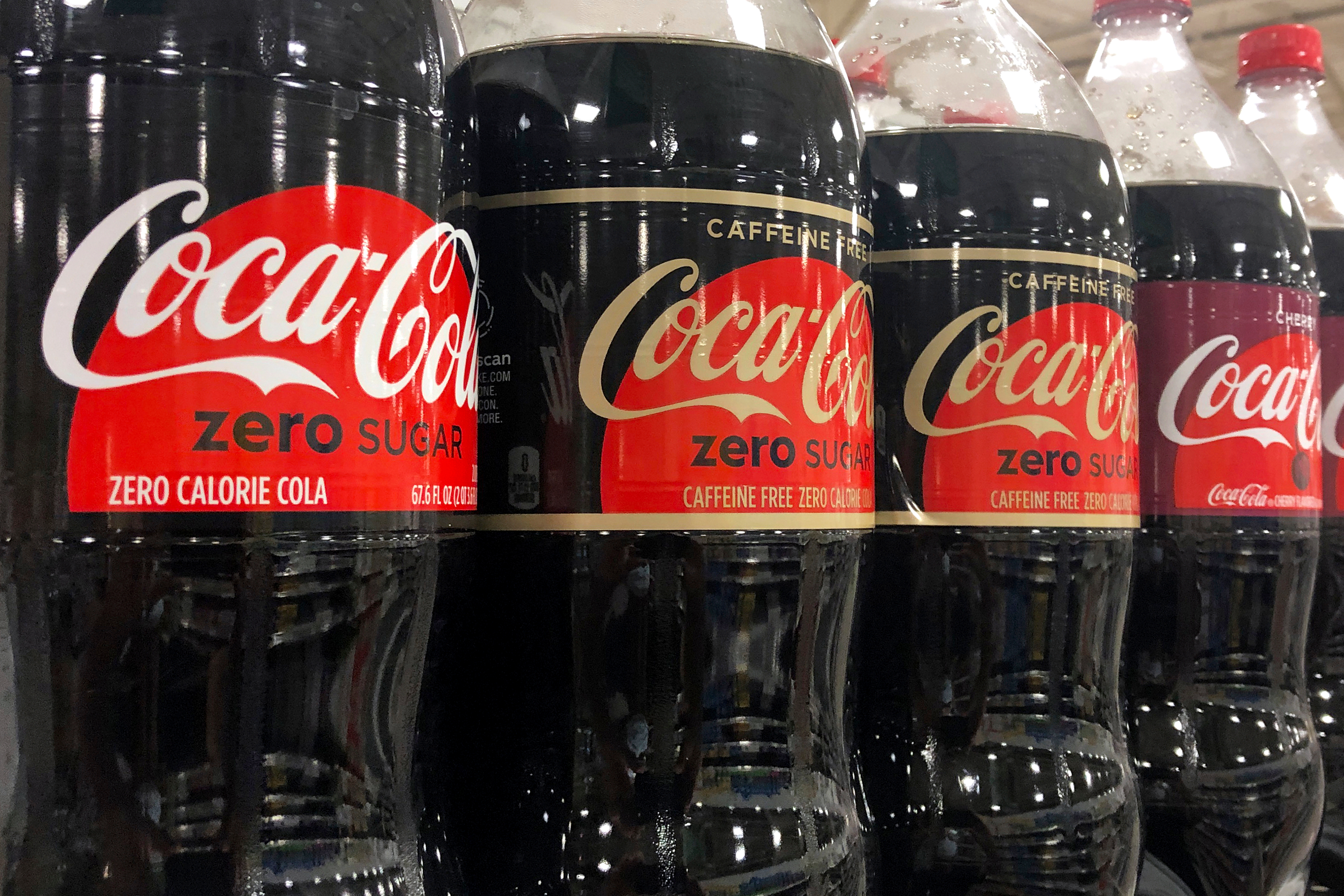 Bottles of Coca-Cola products sit on a shelf at a store in Dania Beach, Fla., Oct. 20, 2020.