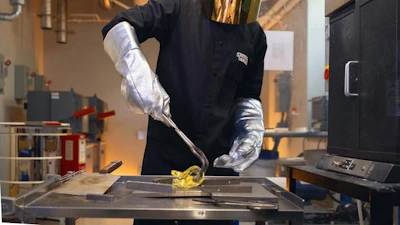 Nicholas Clark, a postdoctoral fellow at Penn State and one of the inventors of LionGlass, molds a piece of glass after removing it from a forge in the team's research lab.