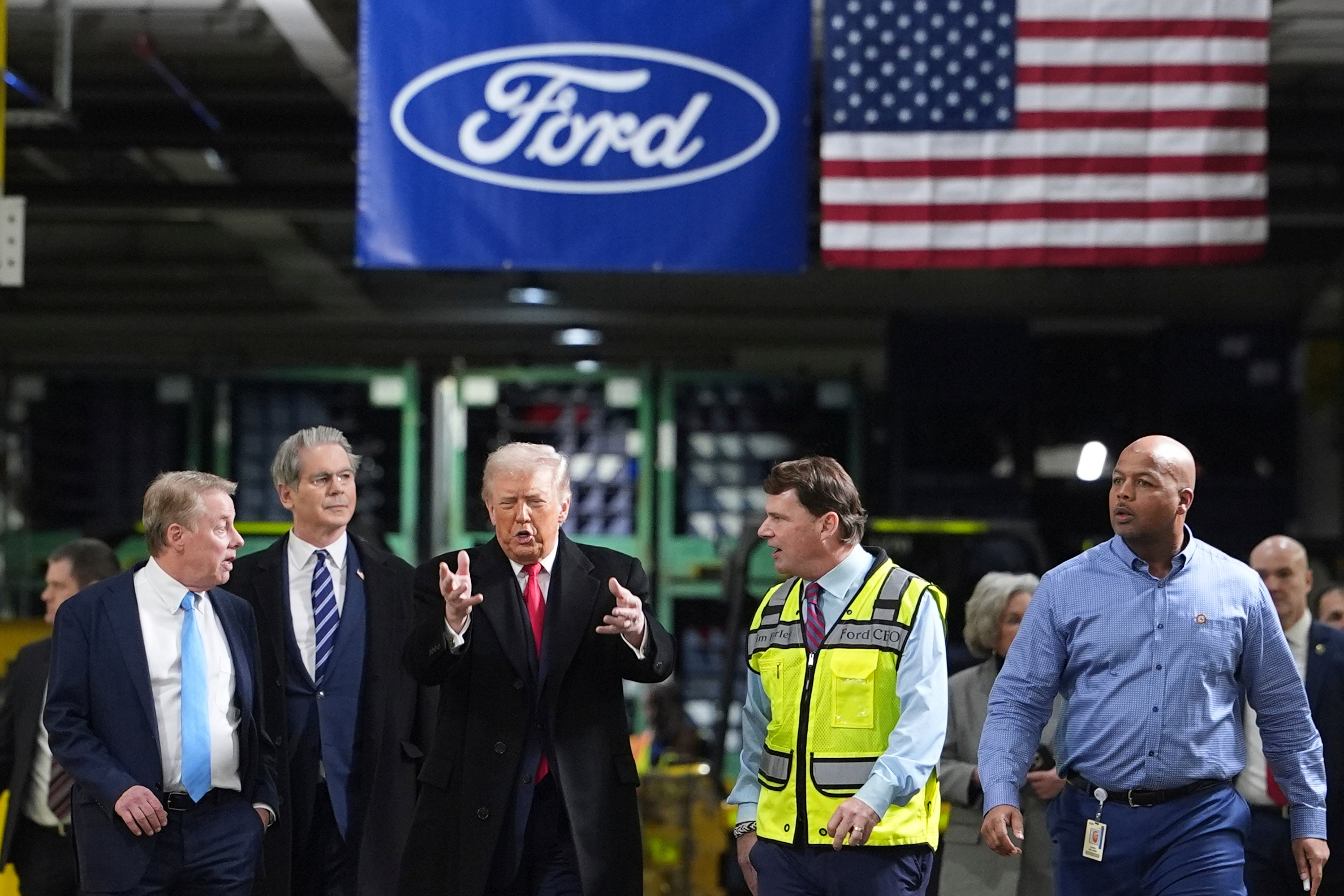 President Donald Trump speaks to, from left Bill Ford, Executive Chairman of Ford, Treasury Secretary Scott Bessent, Jim Farley, CEO of Ford, and Corey Williams, Ford River Rouge Plant Manager, during a tour of the Ford River Rogue complex, Tuesday, Jan. 13, 2026, in Dearborn, Mich.