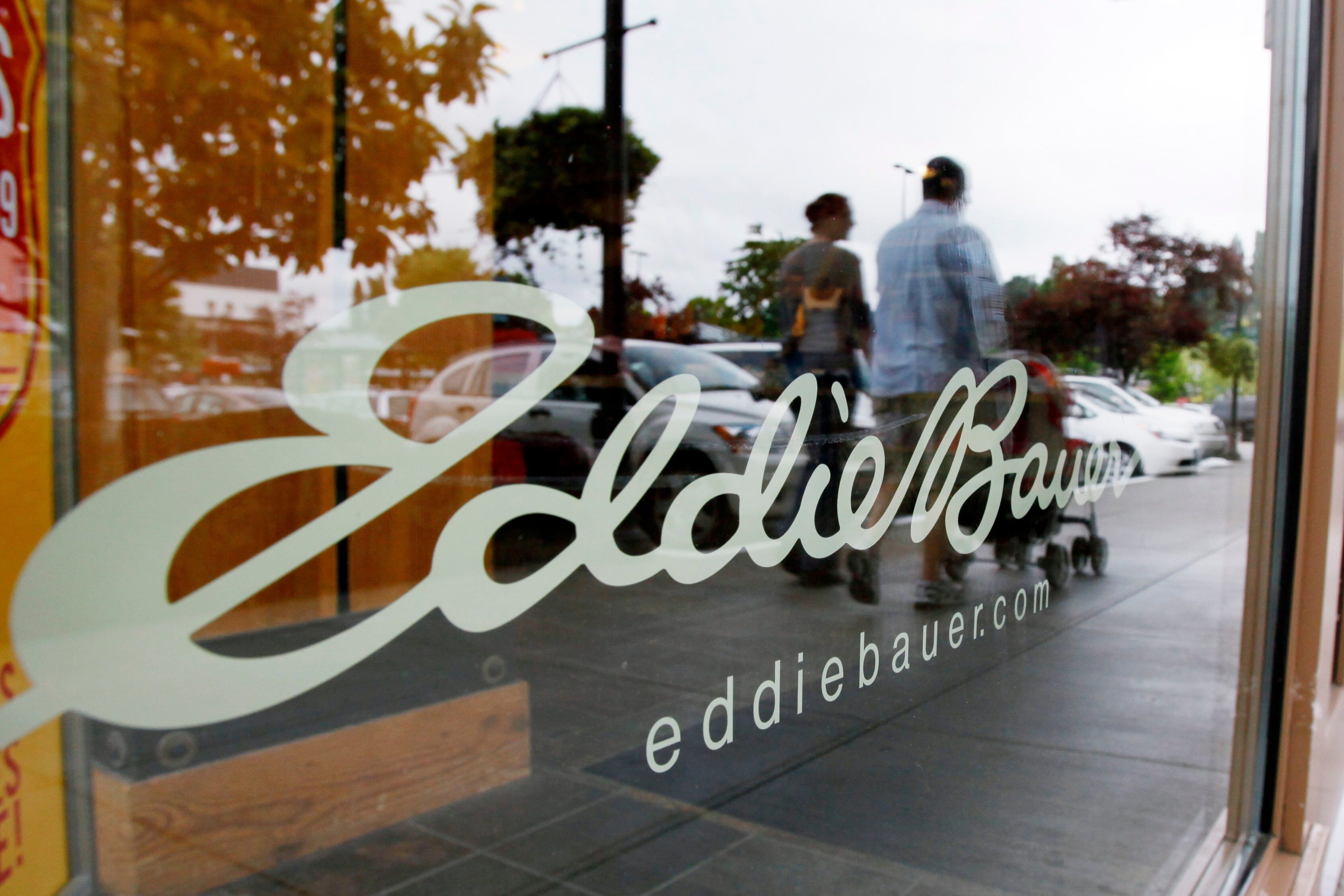 In this June 17, 2009, file photo, shoppers are reflected in the window as they walk past an Eddie Bauer store, in Seattle.