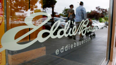 In this June 17, 2009, file photo, shoppers are reflected in the window as they walk past an Eddie Bauer store, in Seattle.