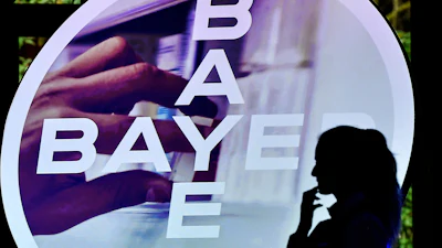 A woman walks in front of a Bayer AG logo at a news conference in Leverkusen, Germany, Feb. 27, 2020.