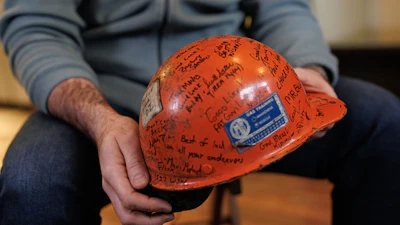 Former U.S. Steel worker Jonathan Ledwich holds his old hard hat at the pizza shop he now owns in Trafford, Pa., on Monday, Dec. 15, 2025.