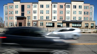 Vehicles pass by the Sapling Grove Apartments, an affordable housing complex, in Aurora, Colo., March 20, 2026.