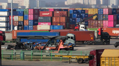 Trucks run by containers at the Uiwang ICD Terminal in Uiwang, South Korea, Thursday, March 12, 2026.