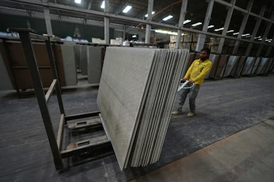 A migrant worker stacks ceramic tiles in a factory in Morbi, in the Indian state of Gujarat, Wednesday, April 8, 2026.