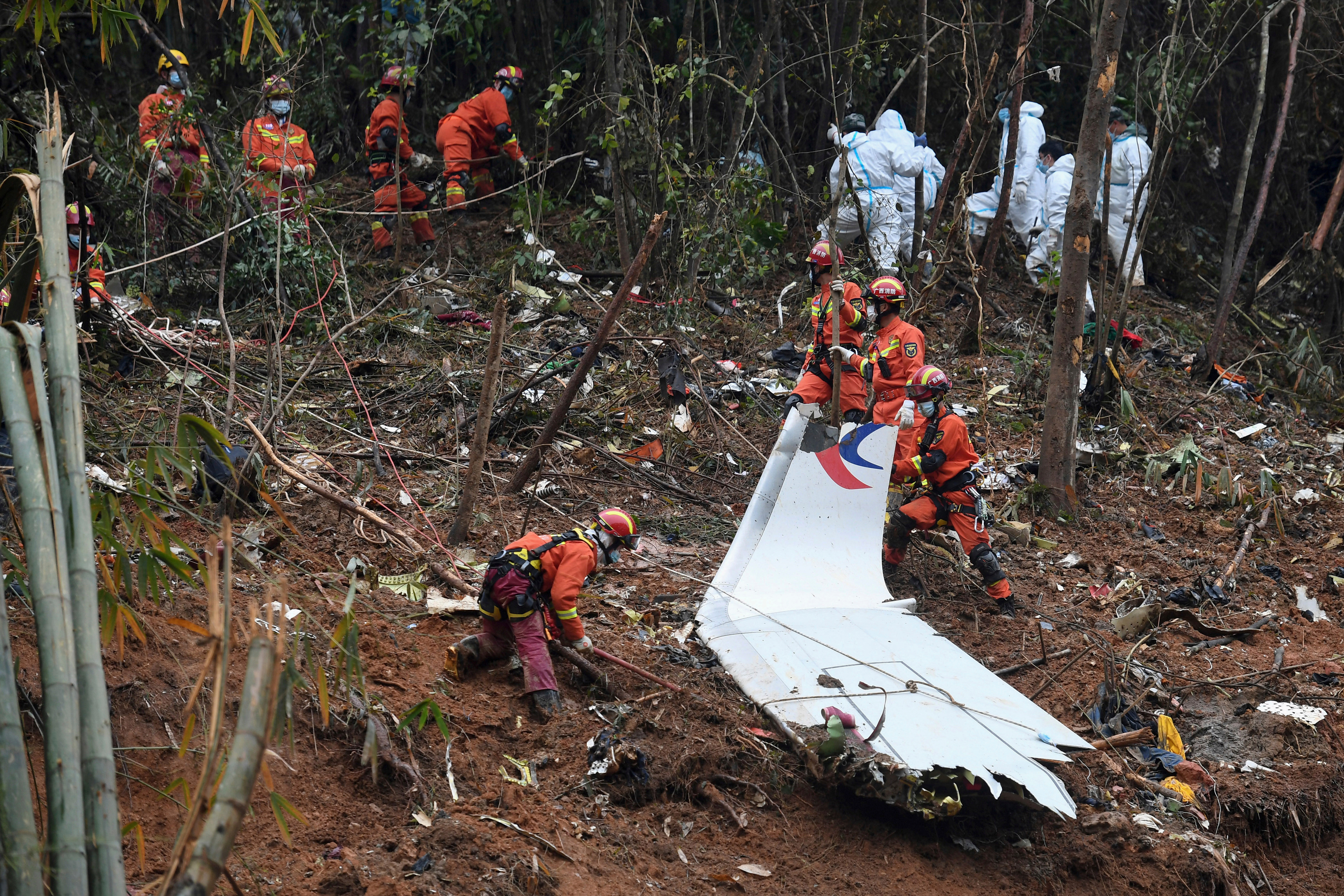 In this photo released by Xinhua News Agency, search and rescue workers search through debris at the China Eastern flight crash site in Tengxian County in southern China's Guangxi Zhuang Autonomous Region on March 24, 2022.