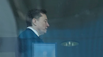 Elon Musk walks through a hallway inside the U.S. District Court in Oakland, Calif., Wednesday, April 29, 2026.