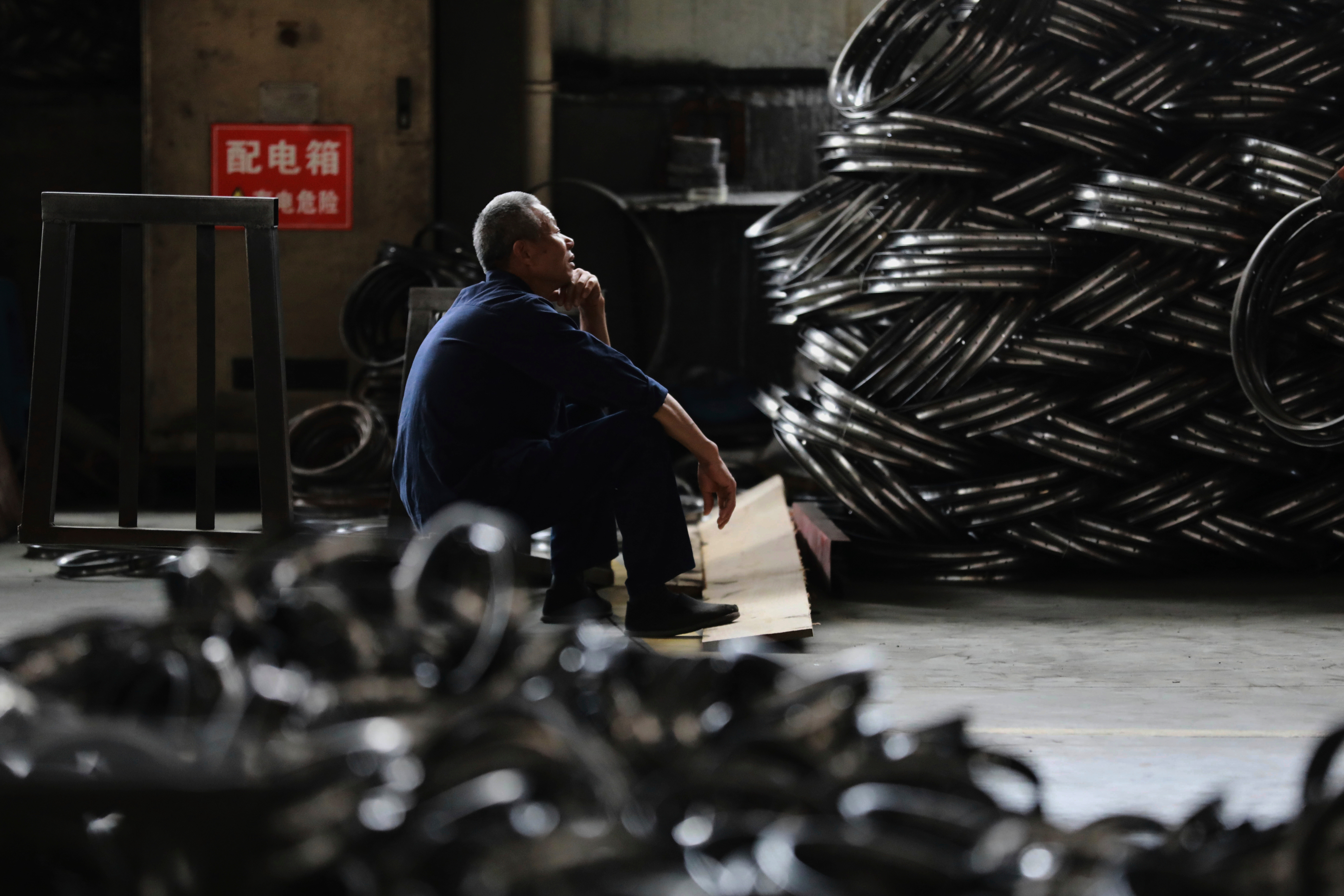 A worker takes a rest at a factory making steel bike rims for export to U.S., in Hangzhou in east China's Zhejiang province, on Friday, April 11, 2025.