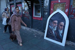 Pedestrians walk past a poster showing slain Iranian Supreme Leader Ayatollah Ali Khamenei, left, and the late revolutionary founder Ayatollah Khomeini, Islamic Revolution square, Tehran, June 14, 2026.
