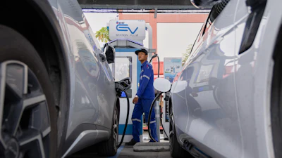 Khatawut Junsongsaeng, a charging station manager, walks past two Chinese-made electric vehicles at a parking lot in Bangkok, Thailand on June 4, 2026.