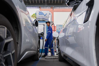 Khatawut Junsongsaeng, a charging station manager, walks past two Chinese-made electric vehicles at a parking lot in Bangkok, Thailand on June 4, 2026.