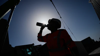 A worker drinks water on a construction site during high temperatures in Boulogne Billancourt, outside Paris, Wednesday, June 24, 2026.