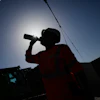 A worker drinks water on a construction site during high temperatures in Boulogne Billancourt, outside Paris, Wednesday, June 24, 2026.