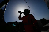 A worker drinks water on a construction site during high temperatures in Boulogne Billancourt, outside Paris, Wednesday, June 24, 2026.