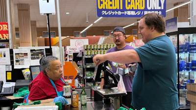 An employee checks a customer's identification card before checking out alcohol at a grocery store in Arlington Heights, Ill., July 6, 2026.