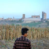 A farmer stands on a corm field as a cement factory seen in the background in Kendeng Mountains in Rembang, Central Java, Indonesia, Friday, June 19, 2026.