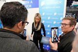 A Realbotix humanoid robot, center, speaks with attendees at a Realbotix booth during the CES tech show Jan. 8, 2025, in Las Vegas.