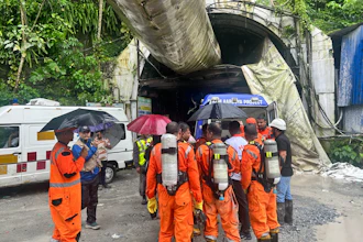 Members of the rescue team carry oxygen cylinders outside the entrance to an under-construction tunnel at a hydropower project in Samardung village, about 40 kilometers (25 miles) from Gangtok, India, Tuesday, July 21, 2026.