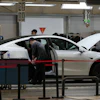 People work on the Tesla Model Y production line at the Tesla Gigafactory assembly plant during a media organized tour, in Shanghai, China, Tuesday, April 14, 2026.