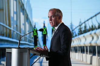 Professional man speaking at podium during outdoor event with construction workers and modern buildings in background