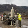 A technician pulls soil samples.