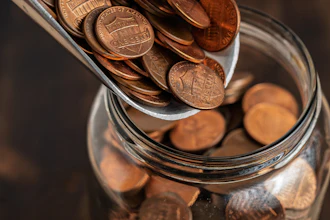 Copper pennies pouring into a glass jar for savings and financial planning