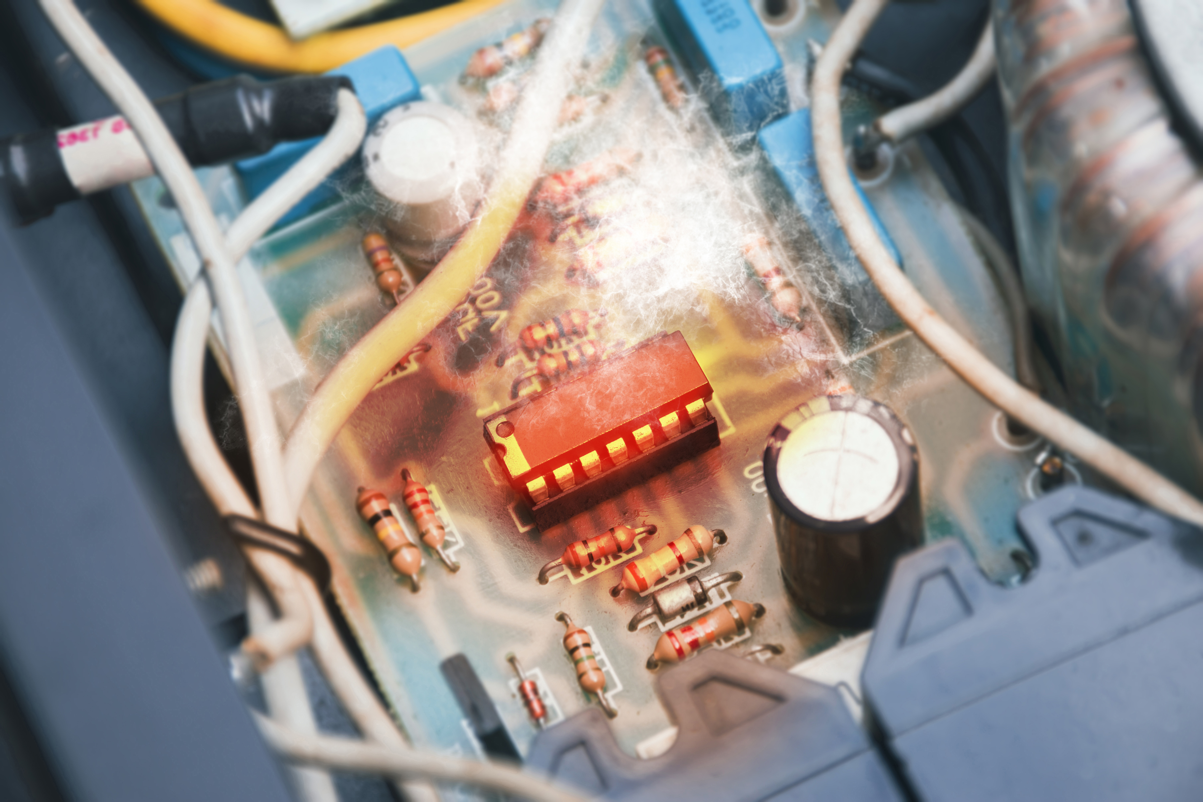 Close-up of circuit board interior with red LED component, resistors, and white wiring visible