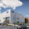 Modern Carrier HVAC dealership facility with white exterior, blue signage, and yellow equipment canopy under blue sky