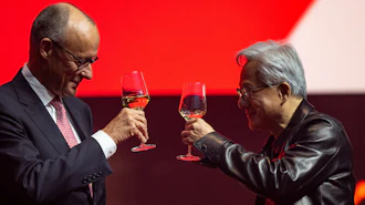 Two professionals toasting with glasses of whiskey against a red background during a formal event