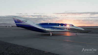 Virgin Galactic SpaceShipTwo aircraft on runway at sunset with illuminated cabin windows