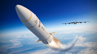 White rocket launching with flames against blue sky, military transport aircraft flying in background