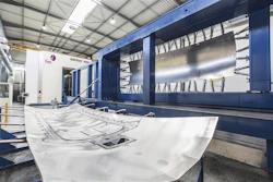 Industrial CNC sheet metal processing machine with blue frame in modern manufacturing facility