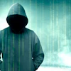 Hooded figure silhouette with digital binary code overlay on teal background representing cybersecurity and hacking