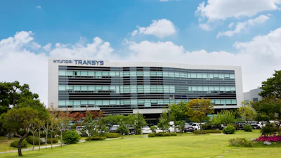 Hyundai Transys modern corporate headquarters building with glass facade and landscaped grounds under blue sky