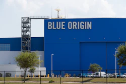 Blue Origin aerospace facility with large blue building facade displaying company name and launch tower