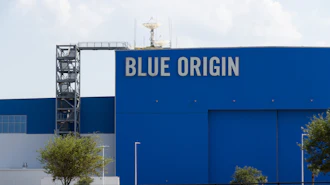 Blue Origin aerospace facility with large blue building facade displaying company name and launch tower
