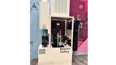 Booster Trolley industrial machine with cream and black components displayed in showroom with pink wall backdrop