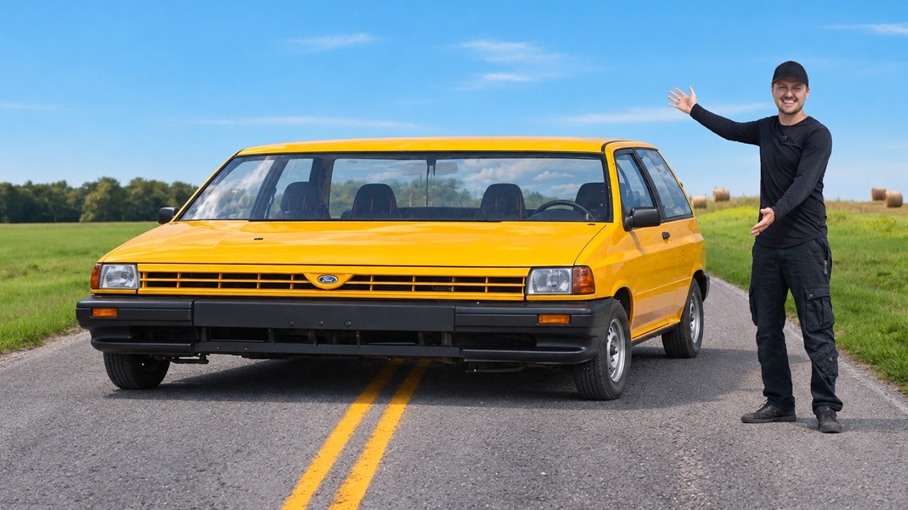 Man in black clothing posing beside a bright yellow vintage minivan on a rural highway with green fields and blue sky