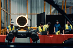 Boston Dynamics robot Spot with glowing head ring displayed at industrial facility with workers in safety vests observing