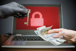 Ransomware extortion concept: hands exchanging money and key with padlock symbol on laptop screen