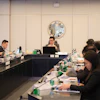 Formal business meeting with professionals seated at conference table in modern office setting