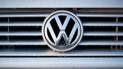 Volkswagen logo on wet vehicle grille with chrome trim