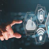 Hand reaching toward glowing hexagonal security icons with Zero Trust text in teal and blue digital interface